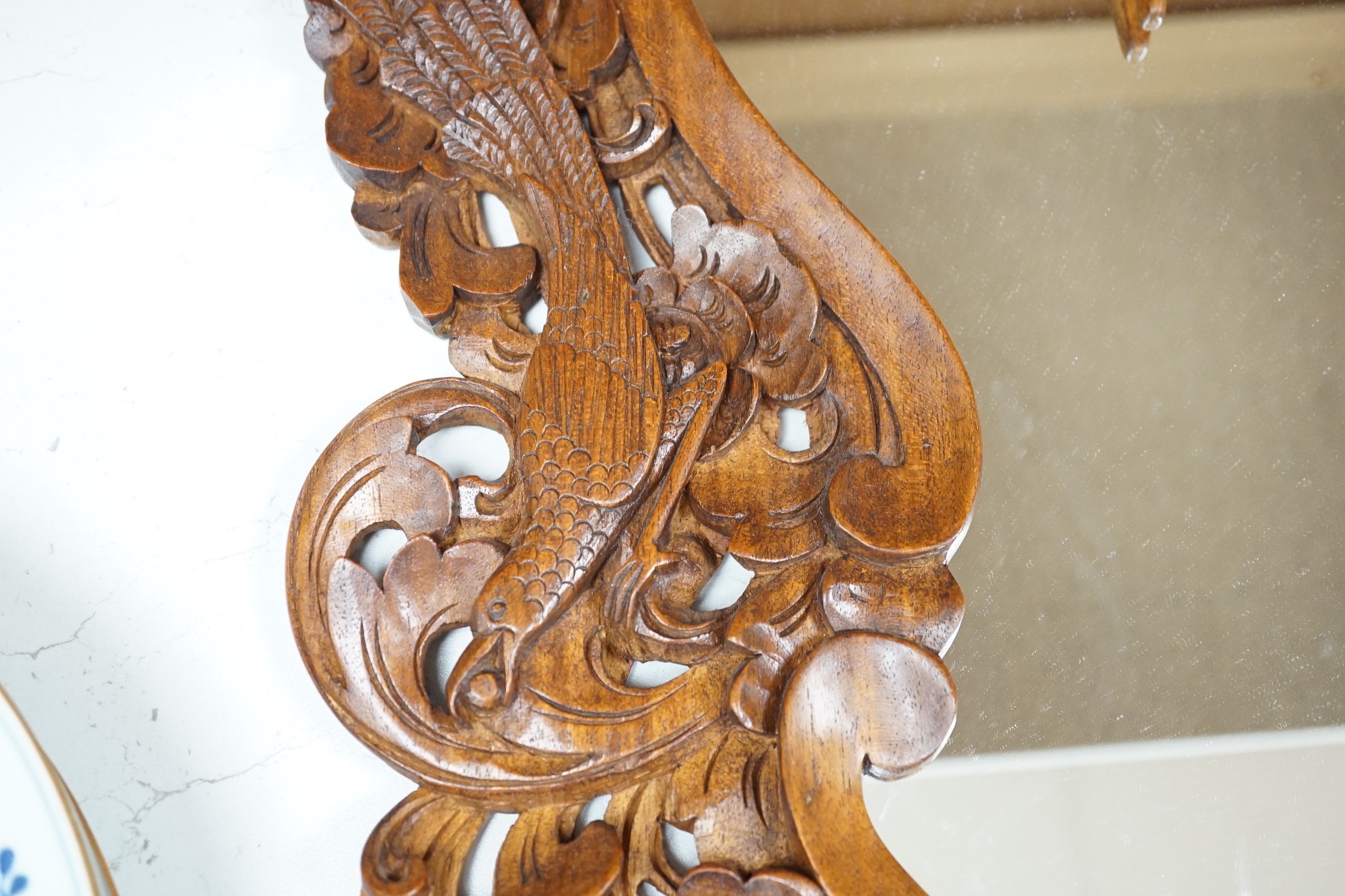A Balinese carved wood wall mirror, 62cm long